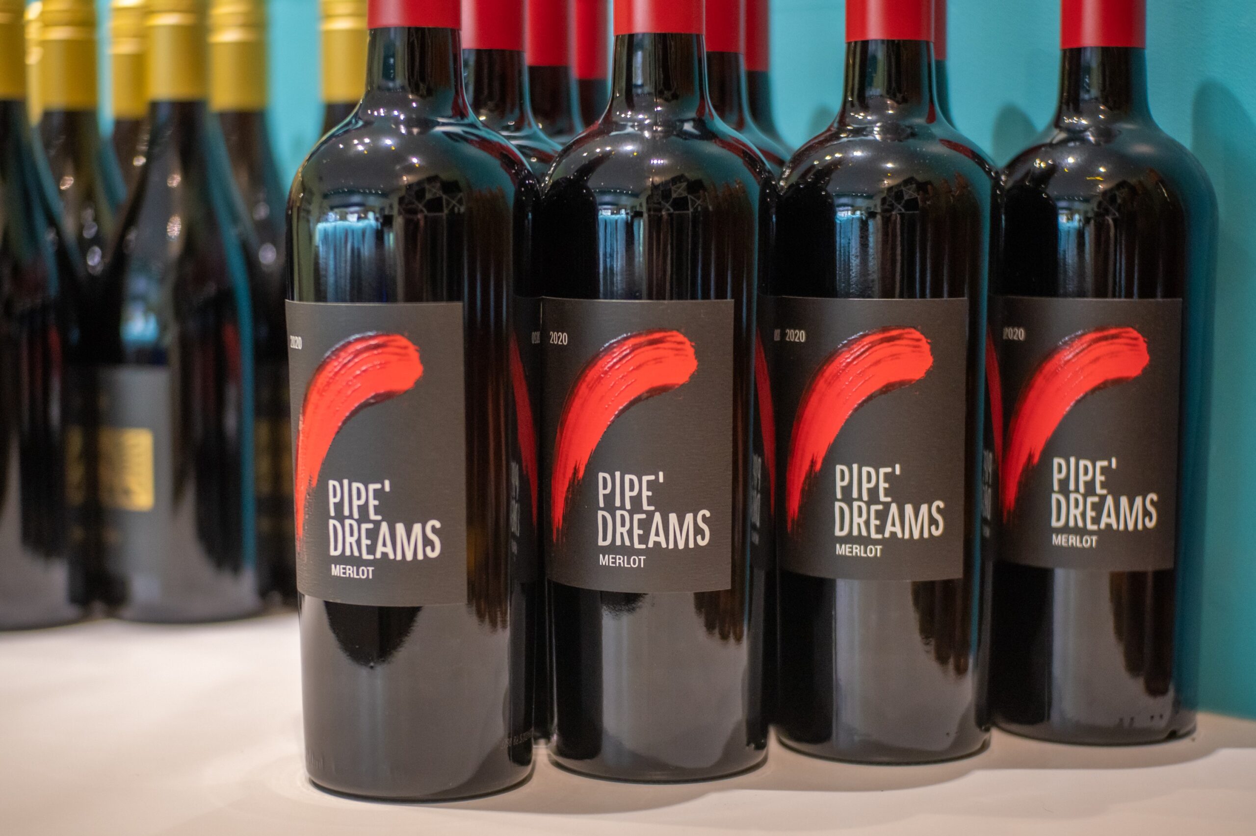 Row of Pipe Dreams Merlot wine bottles on display, perfect for wine lovers and collectors.