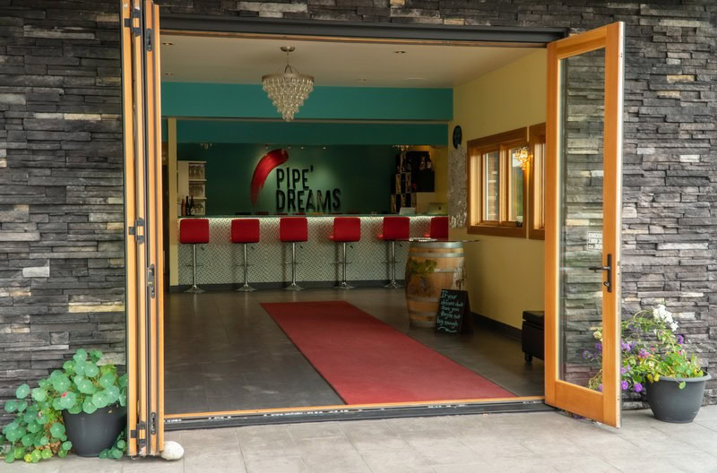 Cozy lounge area with bar stools and a red carpet at Pipe Dreams, a popular venue for social gatherings.